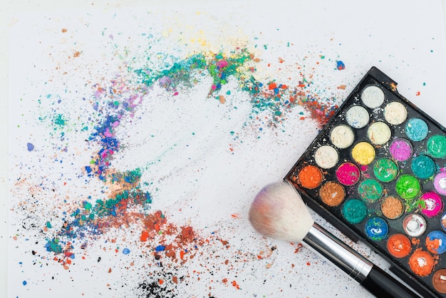 Makeup Brushes on White Background with Colorful Pigment Powder