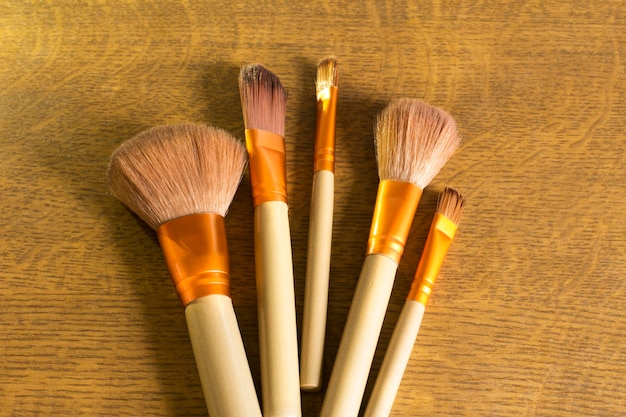 Makeup brushes over a wood background closeup