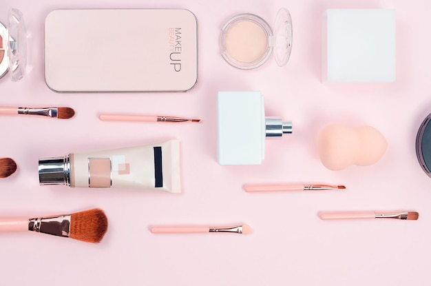 Makeup cosmetic brushes and accessory on pastel pink background