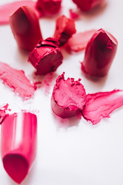 Makeup course. Creative occupation artistry. Pink red lipstick cut samples on white background.