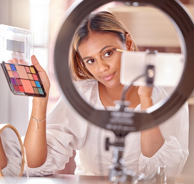 Foto influencer di trucco e donna live streaming con ombretto per cosmetici di bellezza e vlog di moda creatore di contenuti social media e revisione dei record di ragazze e tutorial sulle riprese sul telefono con tavolozza