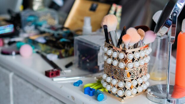 Makeup items, brushes, mirror, eyeliner. Copy space.