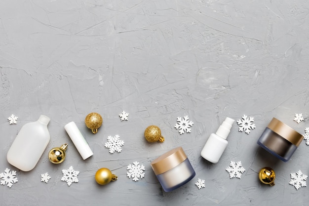 メイクアップ製品と色の背景上のクリスマスの装飾 トップ ビュー コピー スペースと新年ビューティー コンセプト