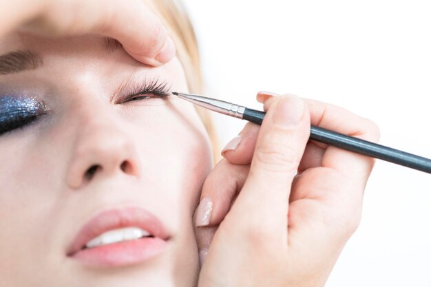 Makeup in the studio Makeup artist performs eye makeup