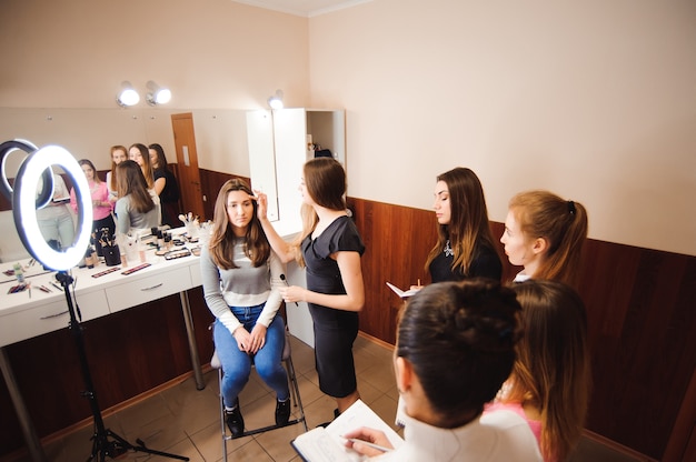 Makeup teacher with her student girls. Makeup tutorial lesson at beauty school. Makeup master class.