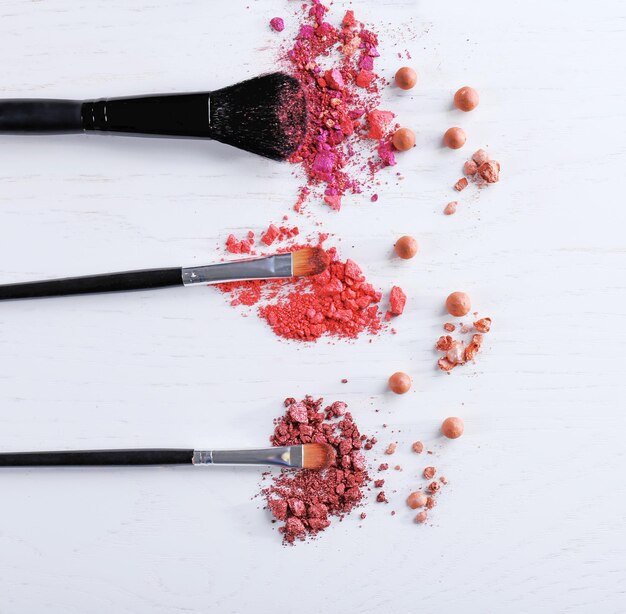 Makeup tools with powder on white background