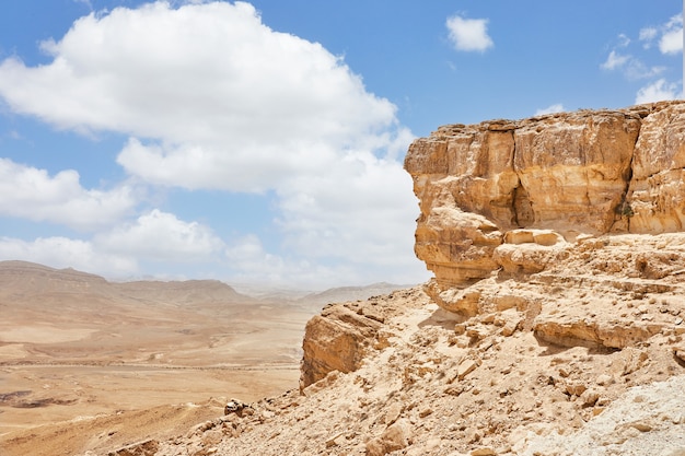 Makhtesh Ramon - Mitzpe Ramon 전망대에서 이스라엘의 Negev 사막에 있는 Ramon 분화구와 Ramon 산을 배경으로 합니다. 색상 모래, 절벽에서 아래로 돌 Negev 사막의 보기.