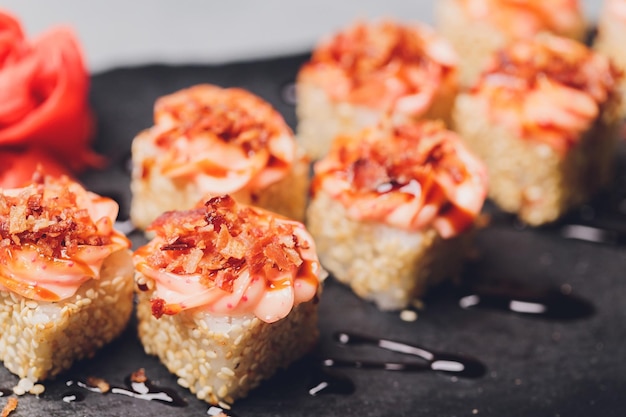 Maki Sushi Rolls met zalm op zwarte steen op donkere achtergrond Met gember en wasabi Sushi menu Japans eten Close-up van heerlijk Japans eten met sushi roll Horizontale foto