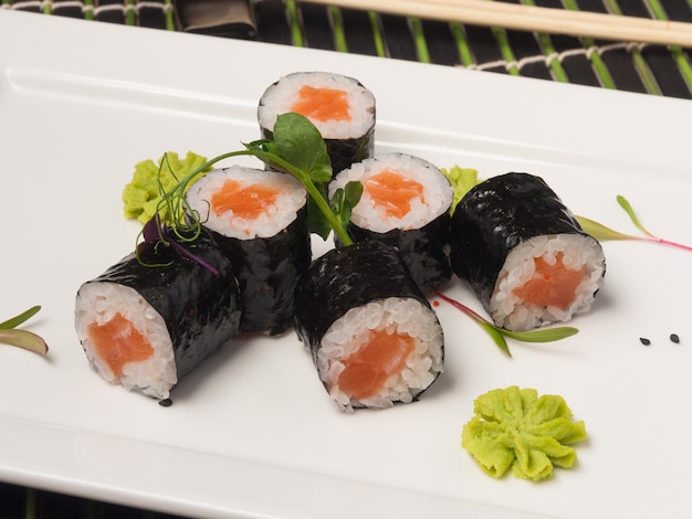 Maki sushi rolt met zalm op een witte plaat close-up