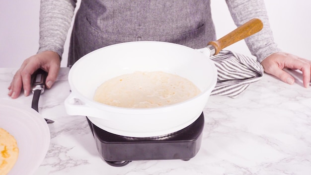 Making crepes in a small frying pan over medium heat.