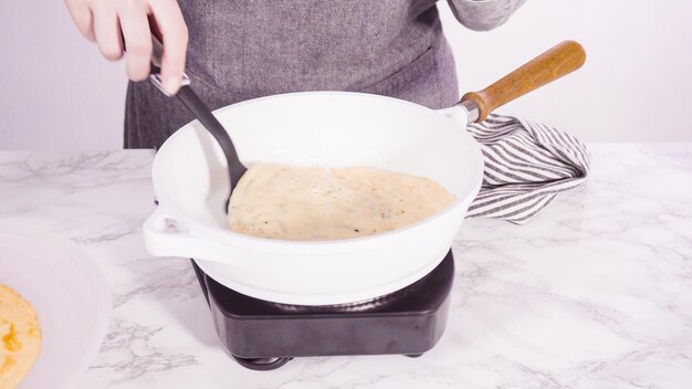 Making crepes in a small frying pan over medium heat.