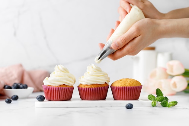 Photo making decorating cupcakes muffins with cream delicious homemade dessert pastry bag