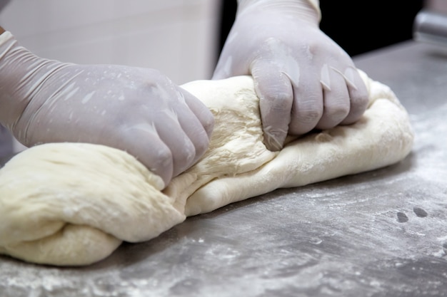 Making dough by female hands at bakery