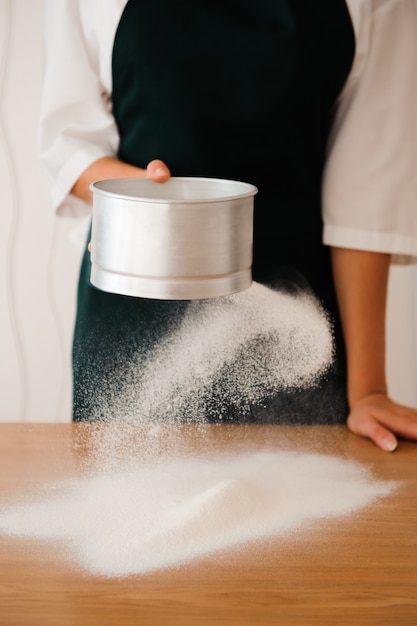 Making dough by female hands at bakery