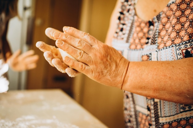 Making dough by female senior hands at bakery. Food concept.