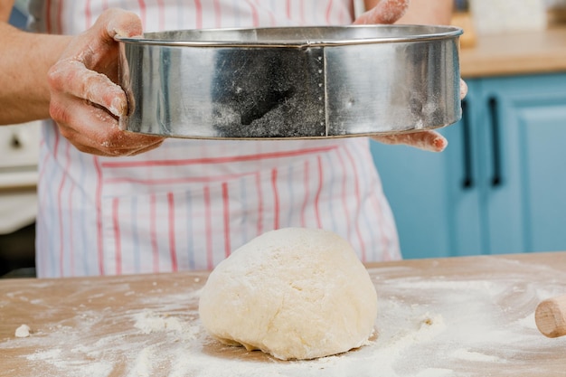 Making dough with men's hands on a wooden table