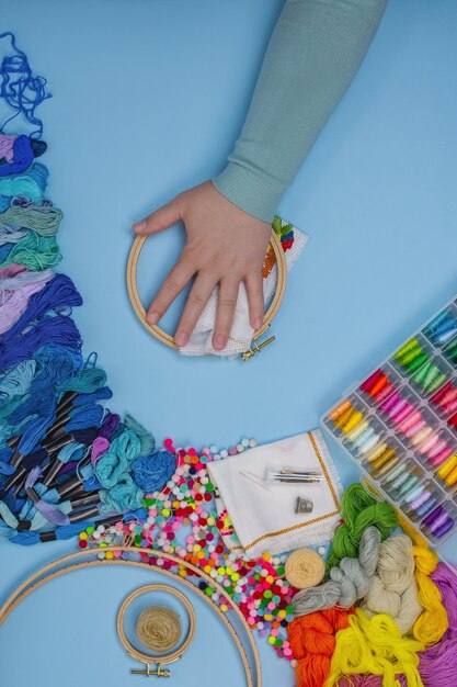 Making embroidery on canvas by womens hands Woman embroidering on table when she have free time