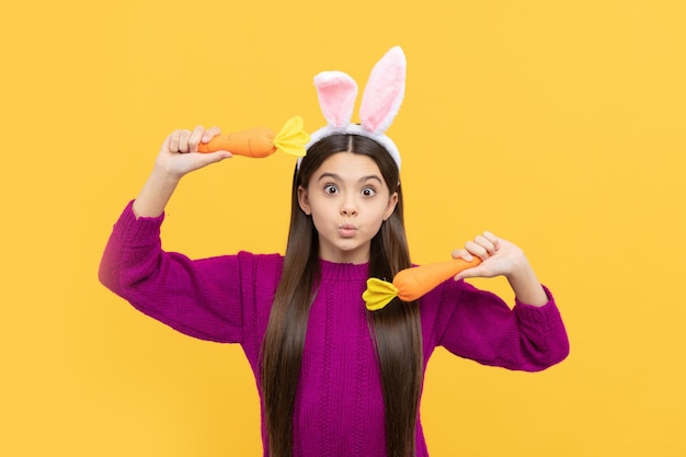 Making faces. funny child in hare ears hold carrot. teenager girl wear rabbit costume. easter bunny hunt. just having fun. ready for party. happy childhood. bunny kid. happy easter holiday.