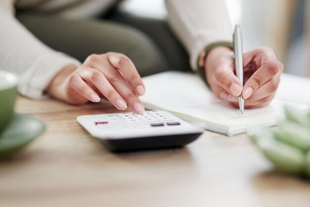 Making a few calculations to ensure shes financially on track Closeup shot of an unrecognisable businesswoman writing notes while using a calculator in an office