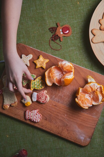 Making gingerbread man, cookie dough. The concept of a feast in the house, a family dinner. New Year traditions concept and cooking process. Cookies on wooden green table.