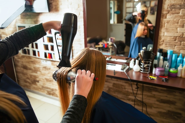 Making hairstyle using hair dryer.