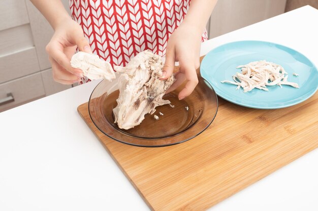 Making a healthy diet broth Female hands cut chicken breast into pieces