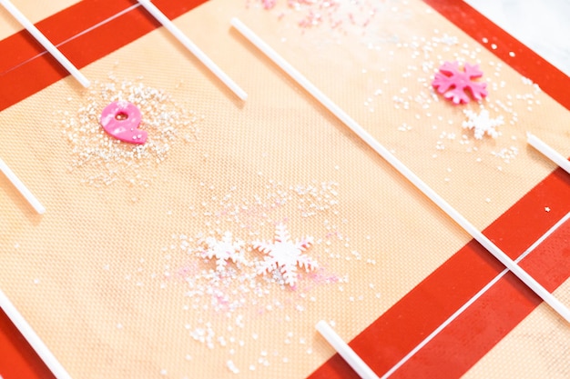 Making homemade berry flavor lollipops with snowflakes