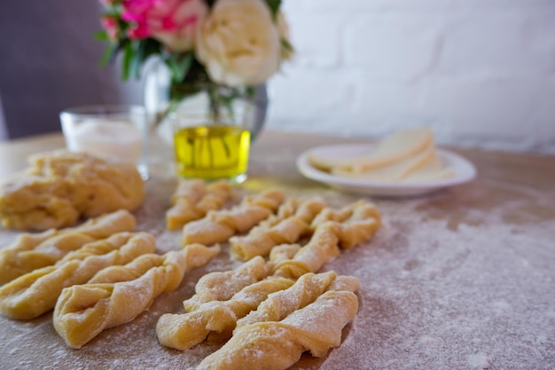 Photo making homemade cakes raw dough butter sugar roses for making brushwood on a wooden tabletop concept on a white brick wall background homemade food during quarantine and lockdown