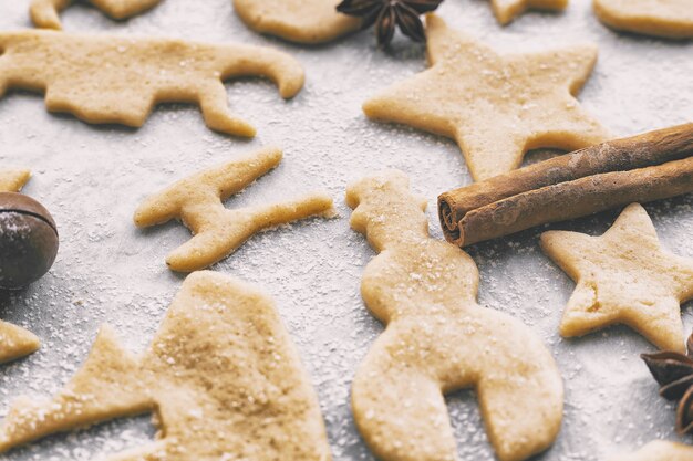 Making homemade christmas or new year cookies of different shapes on parchment craft paper, close-up