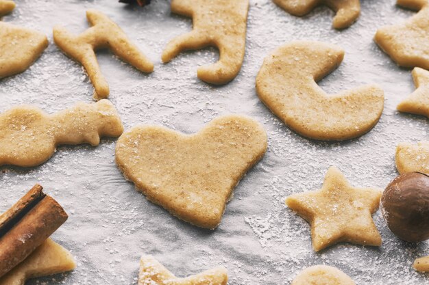 Fare biscotti fatti in casa di natale o capodanno di diverse forme su carta pergamena, primo piano