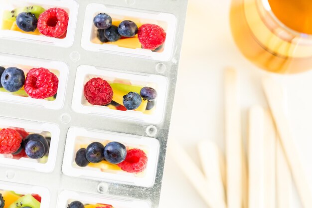 Making homemade fresh fruit popsicles with apple juice.