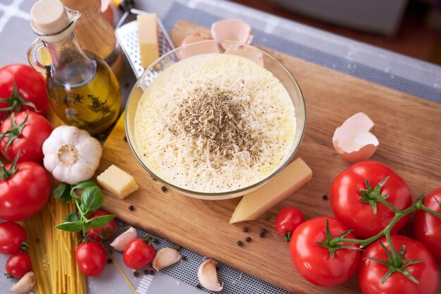 Making homemade pasta carbonara parmesan and cream sauce in a glass bowl