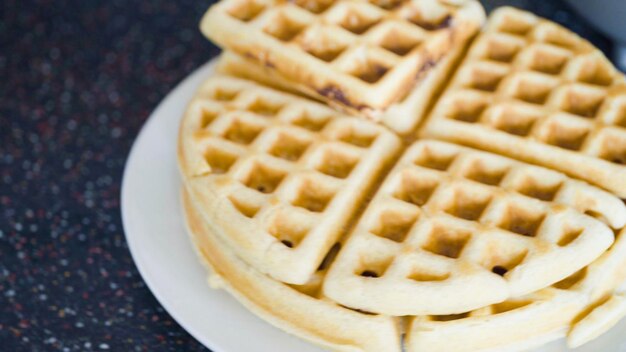 Making homemade waffles in an electric waffle maker.