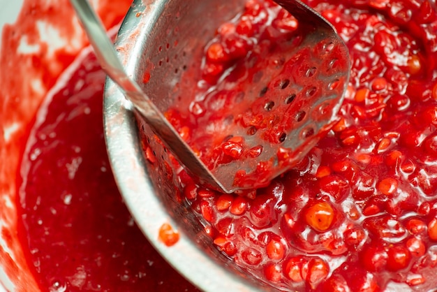 Making jam from guelder rose berries Squeezing guelder rose berries for jam