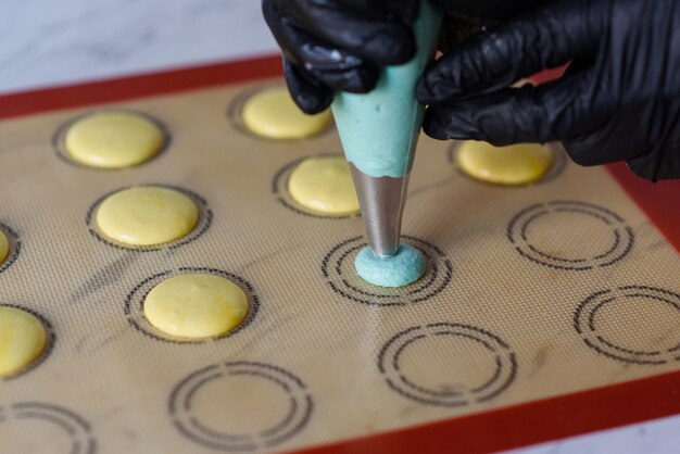 Making macaroonsThe dough from the syringe is squeezed out on a baking sheet