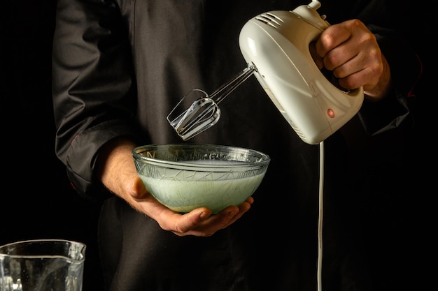 Making a milkshake with an electric hand mixer Refreshing drink by the hands of the chef