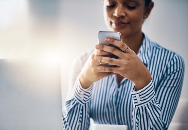 Заставить мобильное ПО работать на себя Снимок: молодая бизнесвумен пользуется мобильным телефоном в офисе