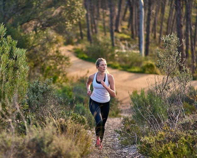 야외에서 운동하는 매력적인 젊은 여성의 아침 샷을 최대한 활용