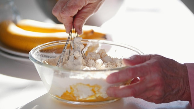 Making pancakes An old woman mixes the ingredients