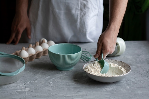 Making pancakes with chef. Chef at his workplace with cooking inventory and ingredients on a dark