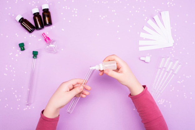 Making perfumes at home. Children's hands make perfume