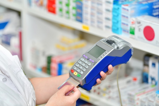 Making purchases, Paying with a credit card and using a terminal on many medicines shelf in pharmacy  .