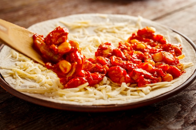 Making of quesadilla. The filling is laid out on the tortilla