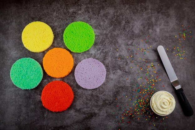 Foto preparare una torta a strati arcobaleno con crema bianca.