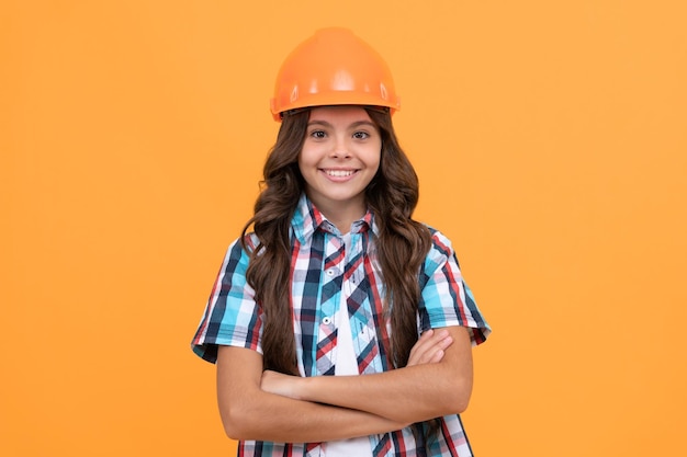 Making repairs happy teen girl in protective hard hat child wear helmet for building protection and safety kid education on construction site improve your childhood future engineer workers day