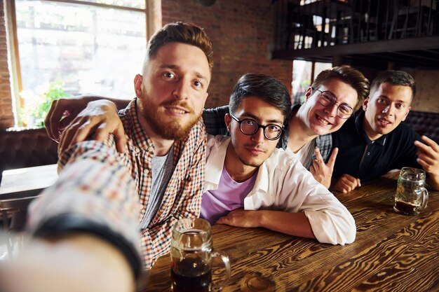 Photo making selfie people in casual clothes sitting in the pub