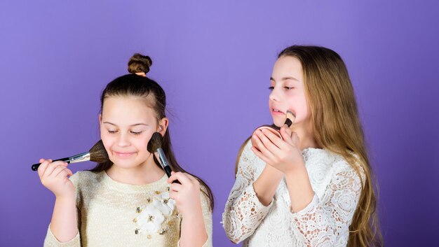 Foto rendere la pelle luminosa con il trucco piccole truccatrici piccole ragazze che truccano la pelle del viso bambini adorabili che scelgono il trucco giusto per il tono della loro pelle