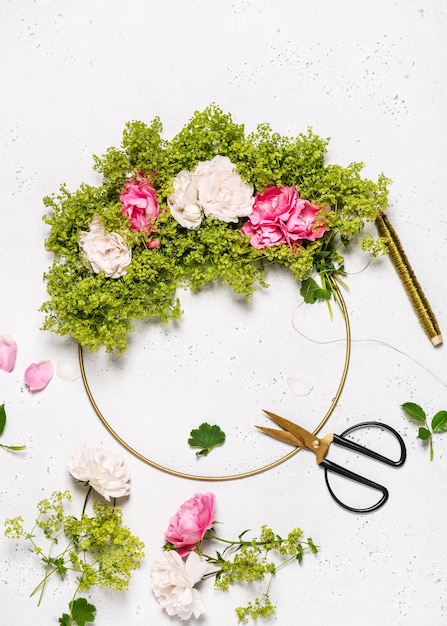 Making summer rosa flowers wreath  with green ladys mantle blossom