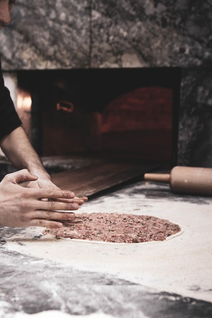 Making a turkish pizza or lahmacun  fast food and popular street food in Mediterranean countries D