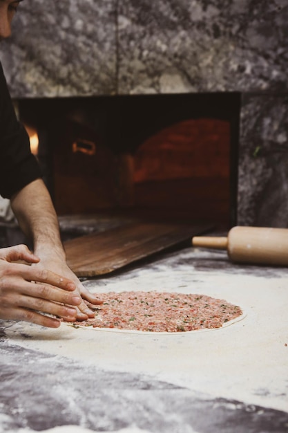 Making a turkish pizza or lahmacun fast food and popular street food in Mediterranean countries